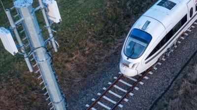Ein Testzug der Deutschen Bahn fährt an einer der Antennenmasten für das 5G-Bahnprojekt vorbei. (Foto: Jens Büttner/dpa)