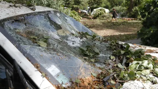 Ein beschädigtes Auto auf einem Campingplatz auf Korsika. (Foto: Pascal Pochard-Casabianca/AFP/dpa)