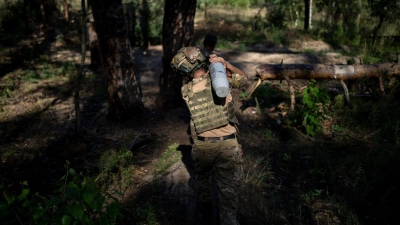 Ein ukrainischer Soldat trägt eine Granate an der Frontlinie in Lyman. (Foto: Bram Janssen/AP/dpa)
