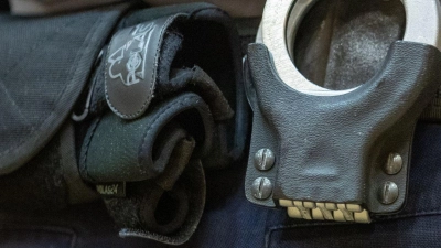 Handschellen stecken in der Gürtelhalterung eines Justizbeamten. (Foto: Friso Gentsch/dpa/Symbolbild)