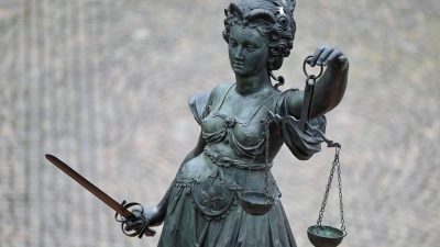Eine Bronzefigur der Justitia mit Schwert und Waage. (Foto: Arne Dedert/dpa/Symbolbild)