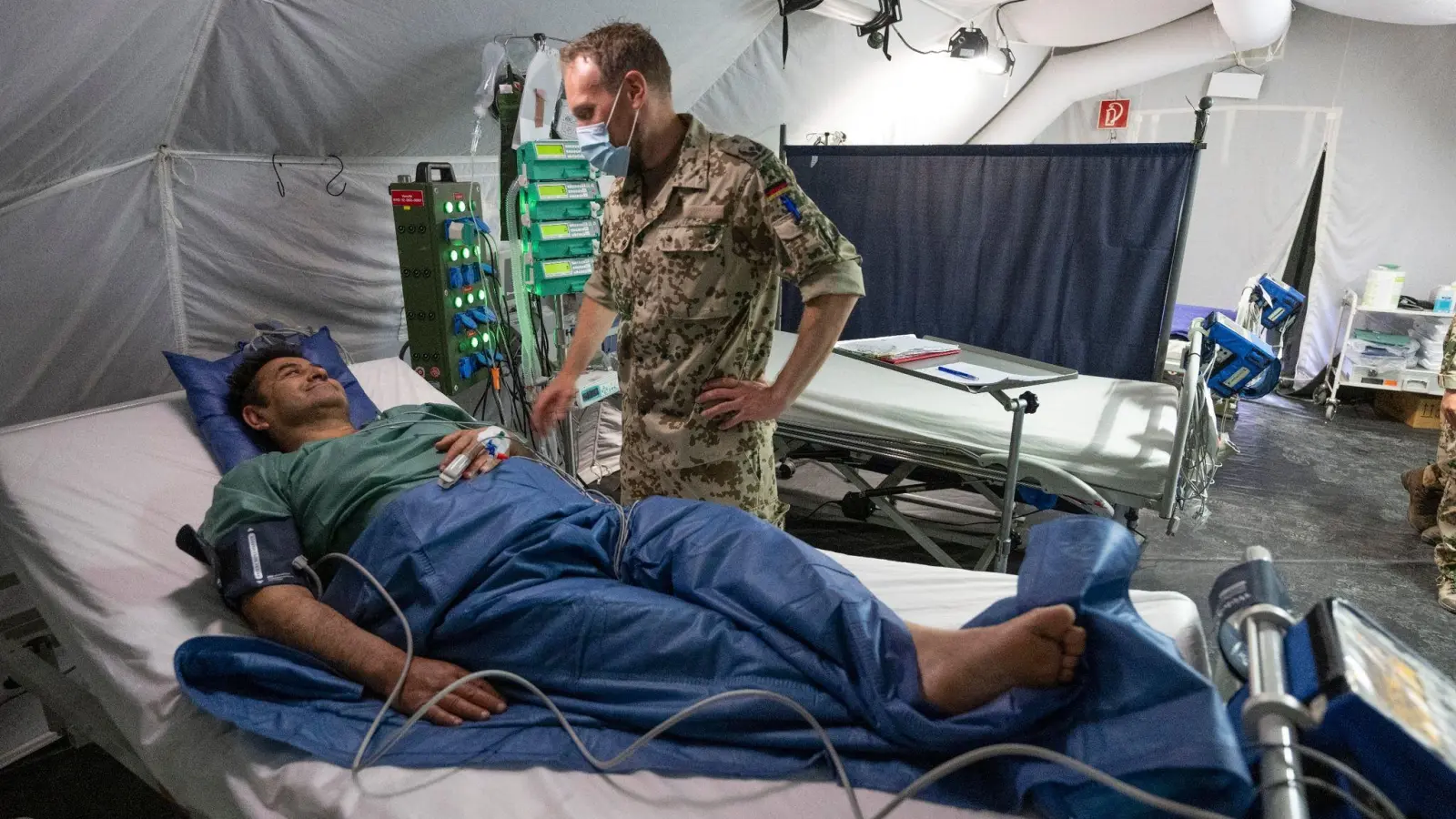 Ein Bundeswehr-Arzt kümmert sich im mobilen Feldkrankenhaus der Bundeswehr um einen Patienten. (Foto: Boris Roessler/dpa)