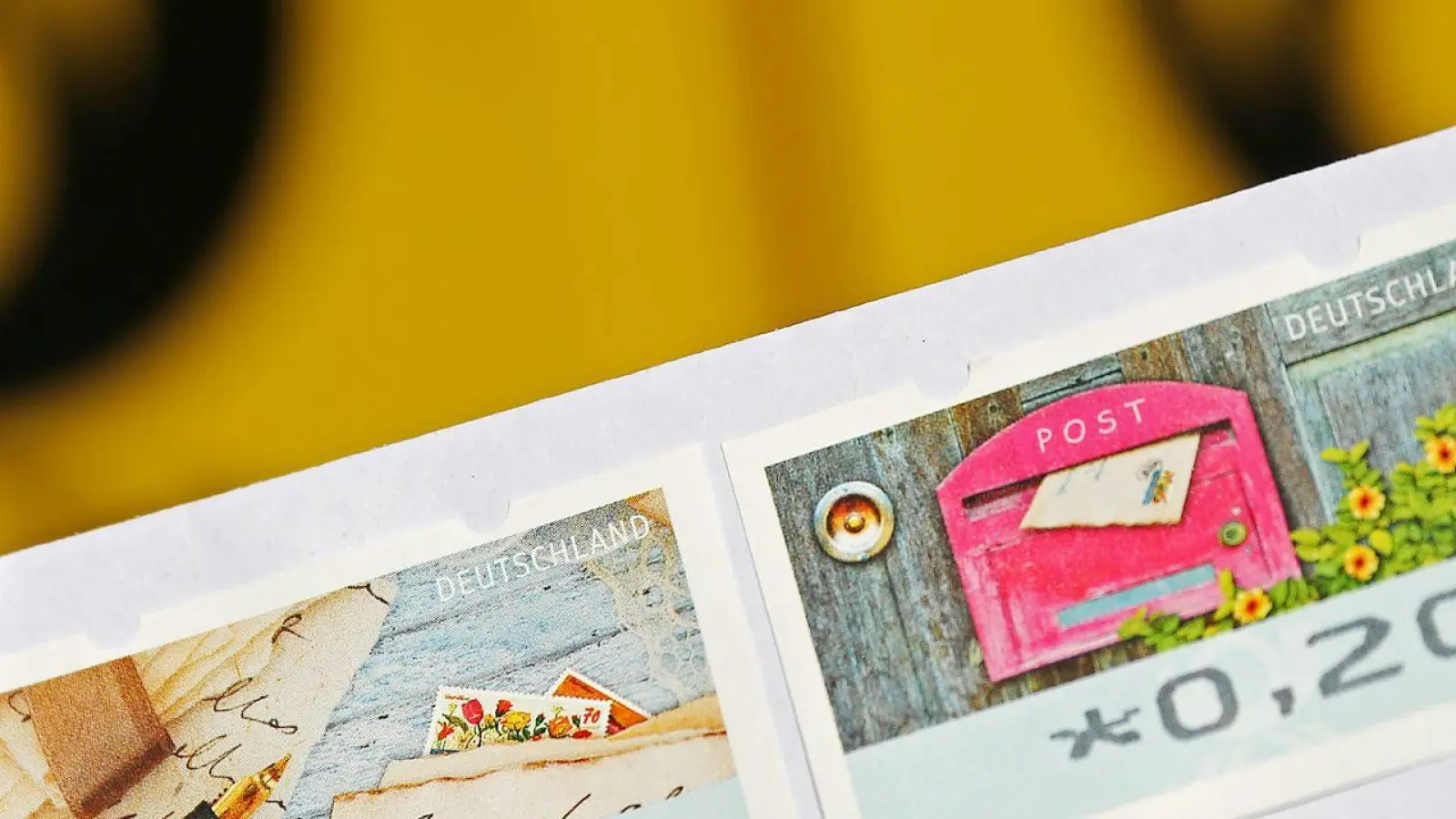 Eine 20-Cent-Briefmarke und eine 70-Cent-Briefmarke kleben auf einen Standardbrief. (Foto: Oliver Berg/dpa/Archivbild)