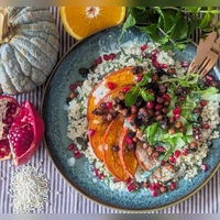 Das Graupen-Bett für den orientalischen Ofenkürbis ähnelt einem Risotto. Die Granatapfelkerne erinnern an rot gefärbte Herbstblätter. (Foto: Doreen Hassek/dpa-tmn)