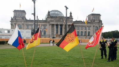 Jahrestag der Erstürmung des Reichstagsgebäudes: Fahnen stehen heute bei einer rechtsextremen Kundgebung vor dem Reichstagsgebäude. (Foto: Paul Zinken/dpa)