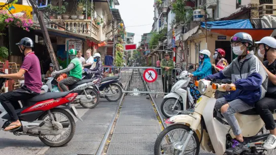 Motorradfahrer überqueren die Train Street in Hanoi, die für Fußgänger gesperrt ist. (Foto: Chris Humphrey/dpa)