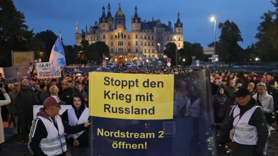 Vor dem Schweriner Schloss treffen sich Teilnehmer einer Demonstration, die gegen die Energiepolitik protestieren. (Foto: Danny Gohlke/dpa)