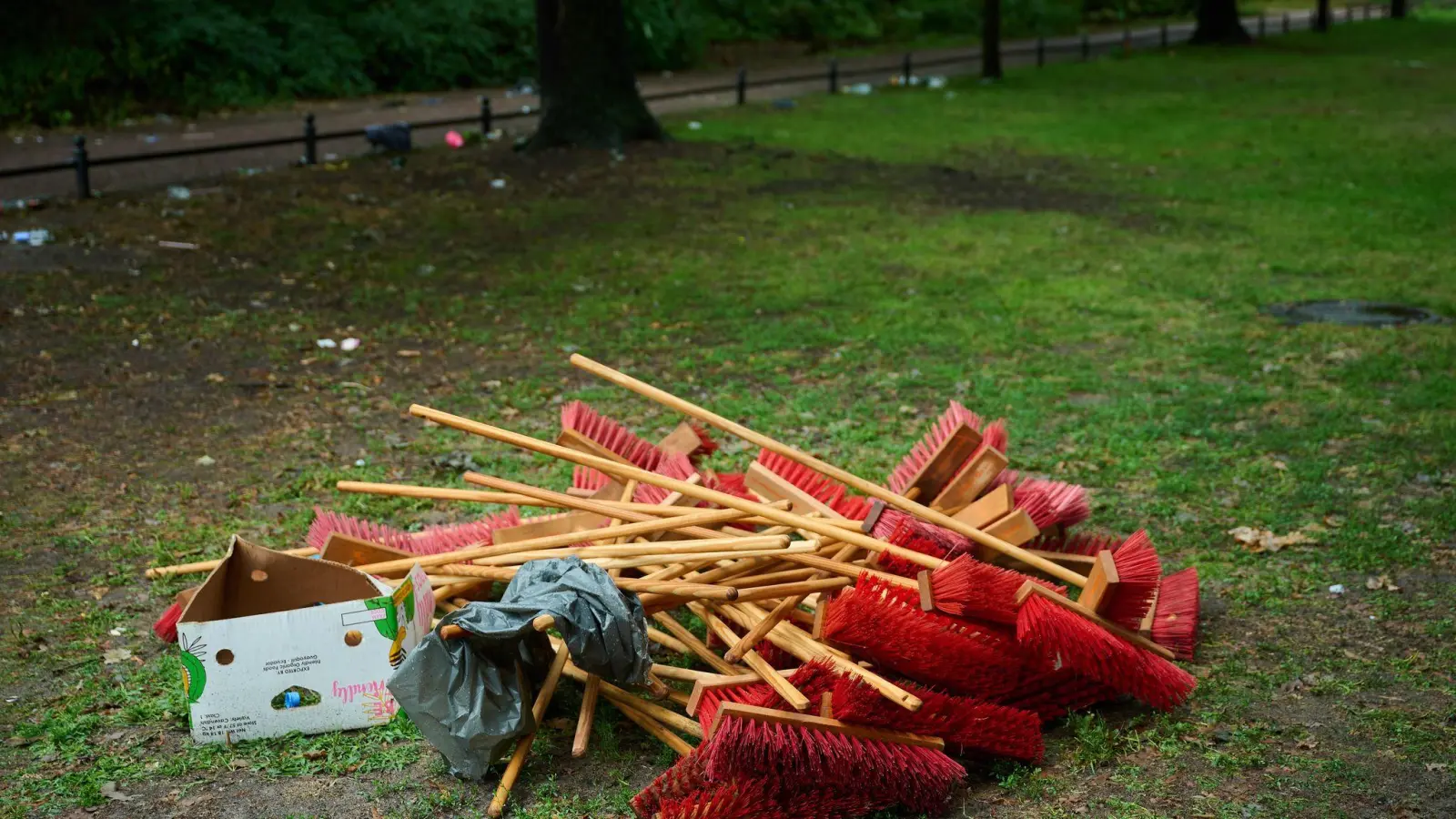 Rote Besen liegen neben der Straße des 17. Juni in Berlin bei den Aufräumarbeiten nach der Techno-Parade „Rave The Planet“. (Foto: Annette Riedl/dpa)