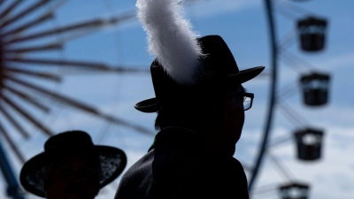 Ein Mann in Tracht steht auf dem Festgelände der Wiesn. (Foto: Sven Hoppe/dpa)