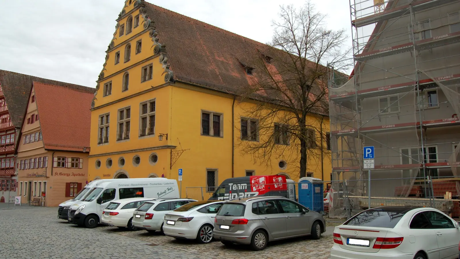 Die ehemalige Sparkasse am Weinmarkt (rechts) wird derzeit zum Hotel umgebaut. Zudem will die Stadt die öffentliche Fläche zur Schranne hin neu gestalten. In diesem Zuge wird nun die im Bild zu sehende Linde „ausgegraben“ und zum Deutschordensschloss versetzt. (Foto: Markus Weinzierl)