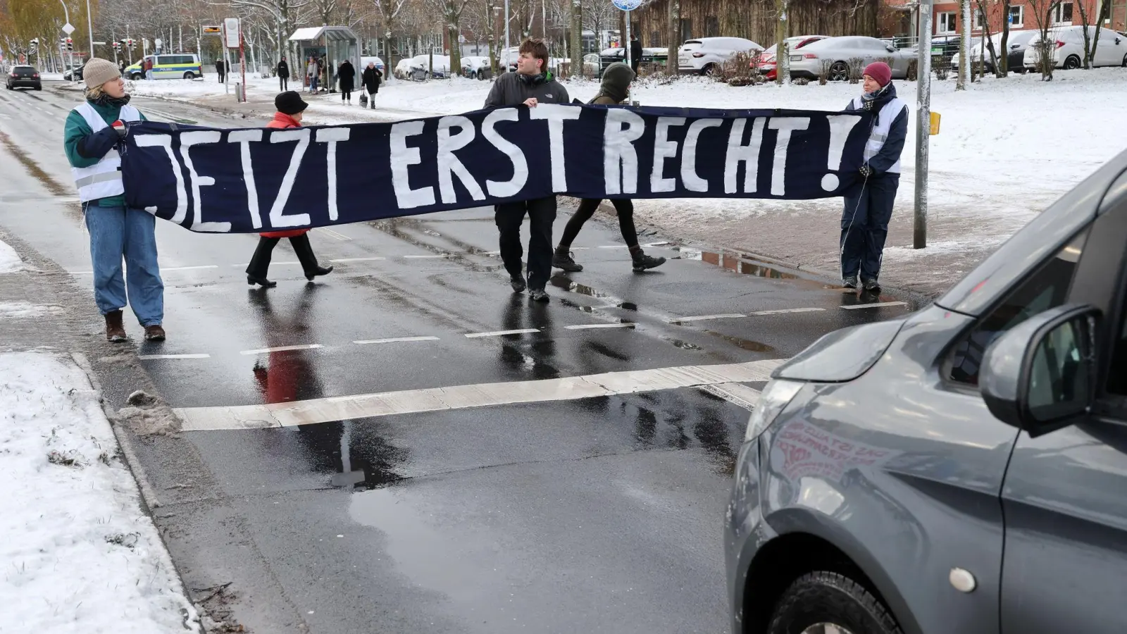 Mitglieder der „Letzten Generation“ blockieren während des Prozesses in Stralsund eine Straße. (Foto: Bernd Wüstneck/dpa)
