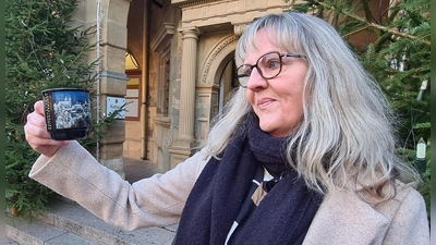Elke Roeder Gonzalez zeigt „ihre” Weihnachtsmarkttasse vor dem Rathaus.  (Foto: Margit Schwandt)