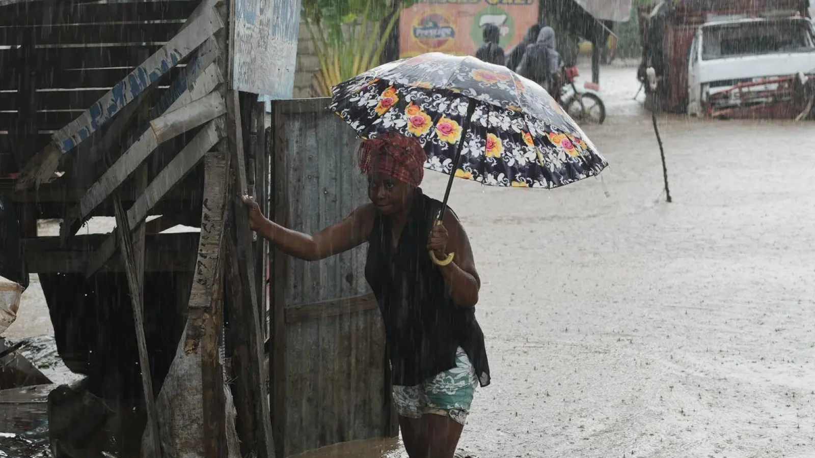 Anwohner waten durch eine überflutete Straße nach dem durchzug von Hurrikan Melissa in Petit-Goave. (Foto: Odelyn Joseph/AP/dpa)
