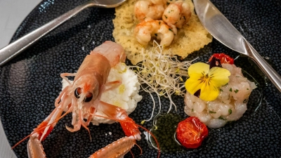 Mal auf Hüttenkäse, mal auf Käsechip: Die Scampi-Trilogie von David Žilić spielt mit Kontrasten zwischen warm und kalt, cremig und knusprig.  (Foto: Andreas Drouve/dpa-tmn)