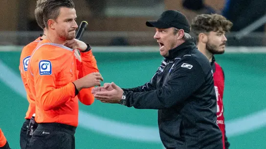 Paderborns Trainer Lukas Kwasniok (r) beschwert sich bei Schiedsrichter Daniel Schlager. (Foto: David Inderlied/dpa)
