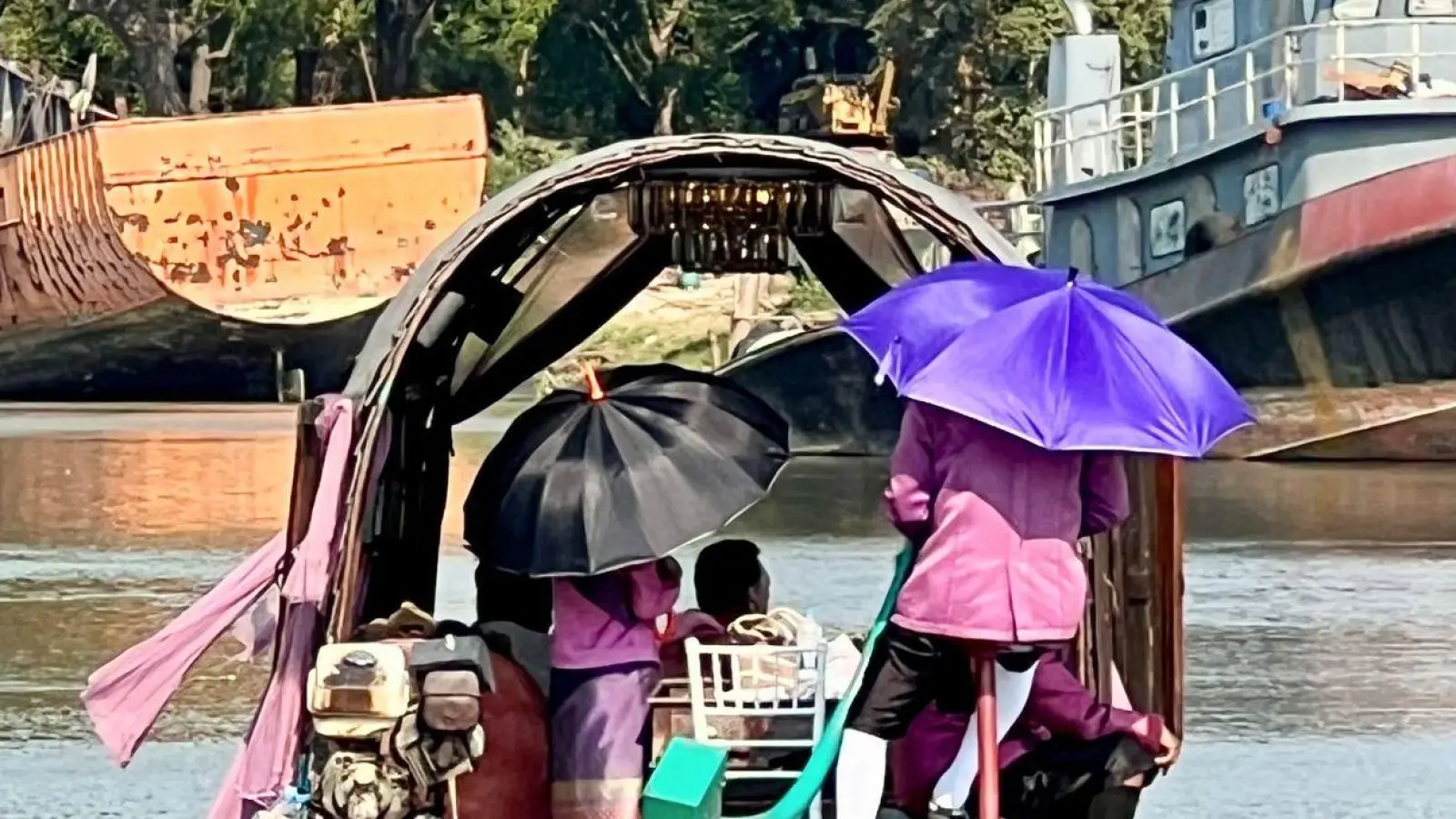 Menschen auf dem Pa Sak River schützen sich mit Sonnenschirmen vor der Sonneneinstrahlung und der extremen Hitze in Thailand. (Foto: Carola Frentzen/dpa)
