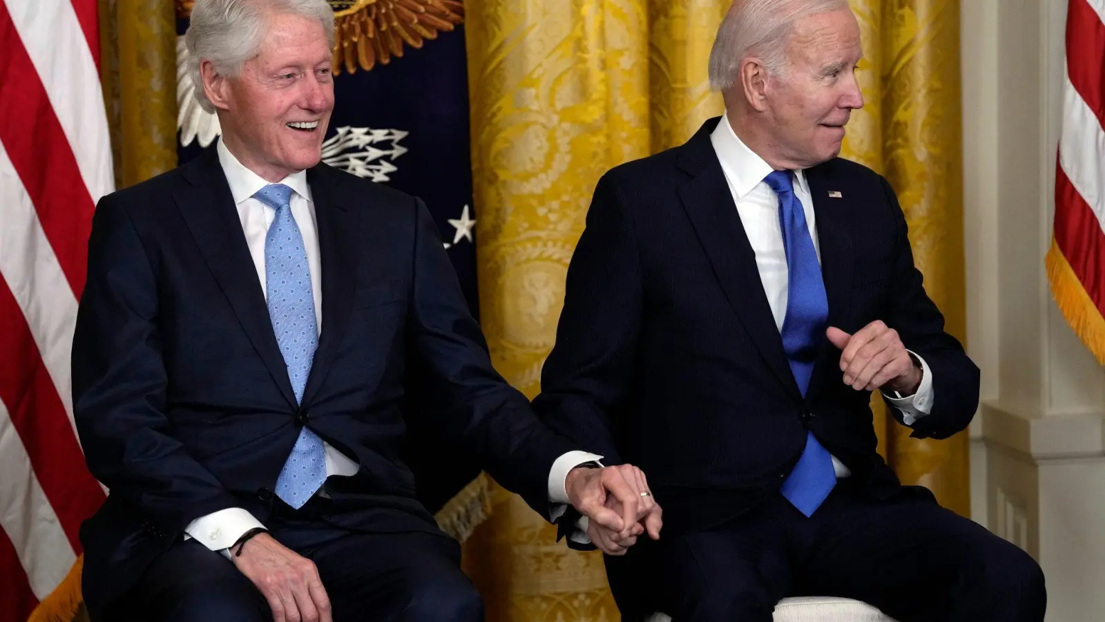 Der Präsident und der Ex: Bei einer Rede von US-Vizepräsidentin Kamala Harris halten sich Joe Biden und Bill Clinton bei den Händen. (Foto: Susan Walsh/AP/dpa)