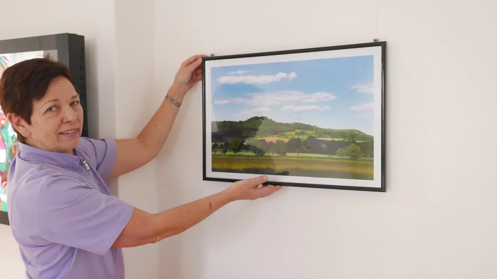 Brigitte Schmidt, Initiatorin der Fotoausstellung, hängt das erste Bild im Erdgeschoss des Pflegeheims an die Wand. (Foto: Roman Kocholl)
