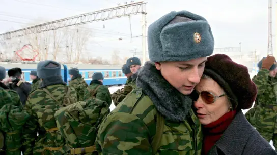 Ein junger Rekrut, der zum Militärdienst einberufen worden ist, umarmt vor der Abreise in die westsibirische Stadt Kemerowo seine Mutter. (Foto: Maxim Shipenkov/epa/dpa)