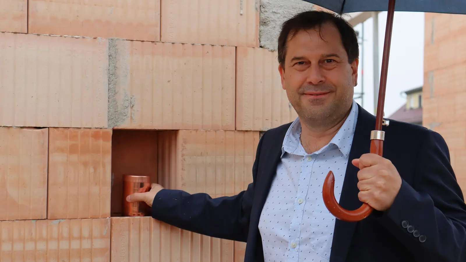 Bürgermeister Stefan Bußinger versteckt die Zeitkapsel im Neubau der Schule. (Foto: Antonia Müller)
