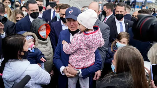 Joe Biden trägt bei seinem Besuch im PGE Narodowy-Stadion, in dem ukrainische Kriegsflüchtlinge untergebracht sind, ein Kind. (Foto: Evan Vucci/AP/dpa)