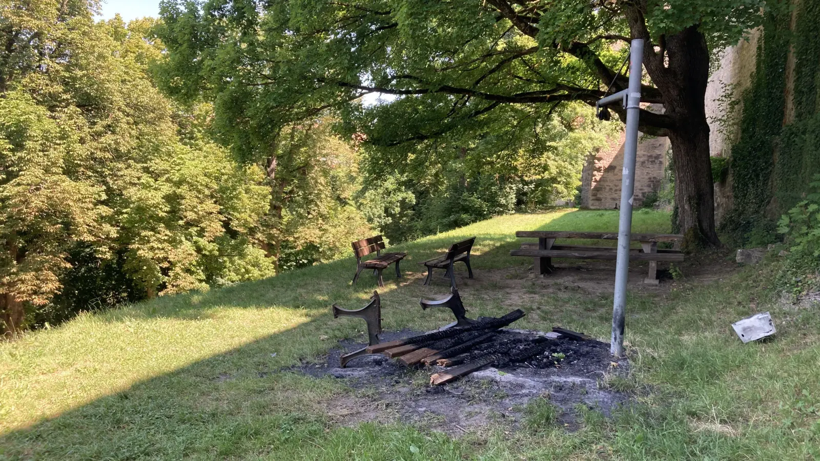 Mitten auf der Feuerstelle am Grillplatz neben dem Kalkturm wurde die verbrannte Bank einfach liegengelassen. (Foto: Clarissa Kleinschrot)