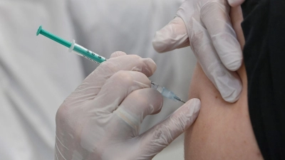 Ein Mitarbeiter eines Impfzentrums impft einen Mann gegen Corona. (Foto: Patrick Pleul/dpa-Zentralbild/dpa/Symbolbild)