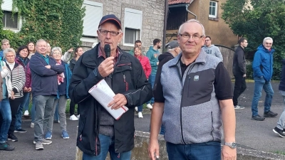 Rund 120 Personen nahmen an der Dorfführung in Herrnberchtheim teil. Die machten Paul Markert mit dem Mikrofon in der Hand und Andreas Zobel. Nachdem Letztgenannter vieles über die Kirche erzählt hatte, spielte er noch ein Lied auf der Kirchenorgel vor. (Foto: Christina Alt)