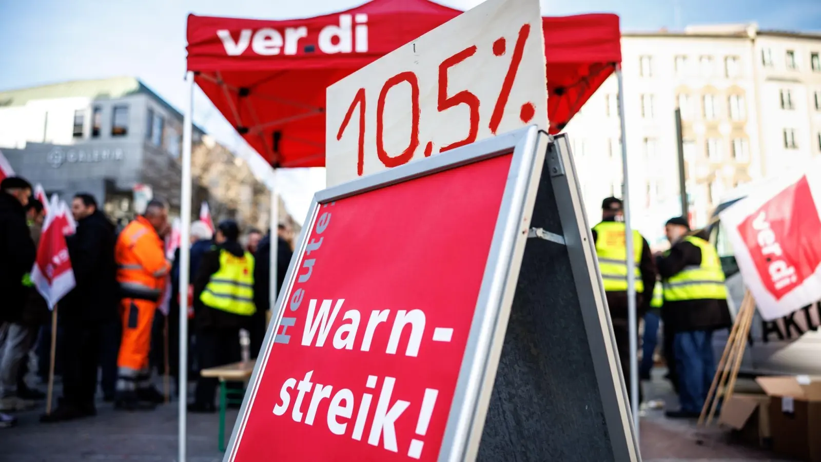 Beschäftigte der Münchner Stadtreinigung stehen bei einer Kundgebung während eines Streiks an einem Verdi-Stand. (Foto: Matthias Balk/dpa/Archivbild)