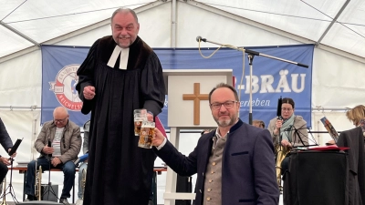 Dombühls Bürgermeister Jürgen Geier und Pfarrer Klaus Lindner stoßen gemeinsam auf die Kirchweih an. (Foto: Gemeinde Dombühl)