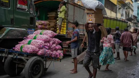 Ein Mann in Colombo mit einer Ladung importierter Lebensmittel auf einem Markt. (Foto: Eranga Jayawardena/AP/dpa)