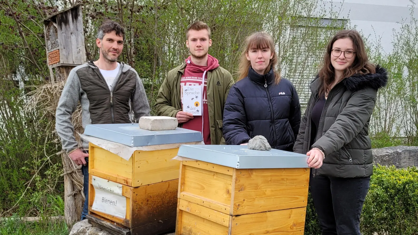 Die beiden Bienenvölker des Steller-Gymnasiums stehen abseits des Schulhofs. Betreut werden sie unter anderem vom Team des P-Seminars „Imkerei“ (von rechts): Kristin Stahl, Naomi Ammon und Benjamin Zapf mit ihrem Lehrer Bastian Stahl. (Foto: Nina Daebel)