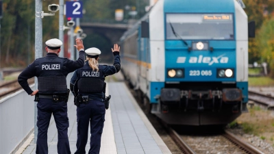 Bundespolizisten weisen per Handzeichen den Lokführer eines Zuges aus Prag in Richtung München darauf hin, dass sie zur Kontrolle des Einreiseverkehrs zusteigen werden. (Archivbild) (Foto: Daniel Karmann/dpa)