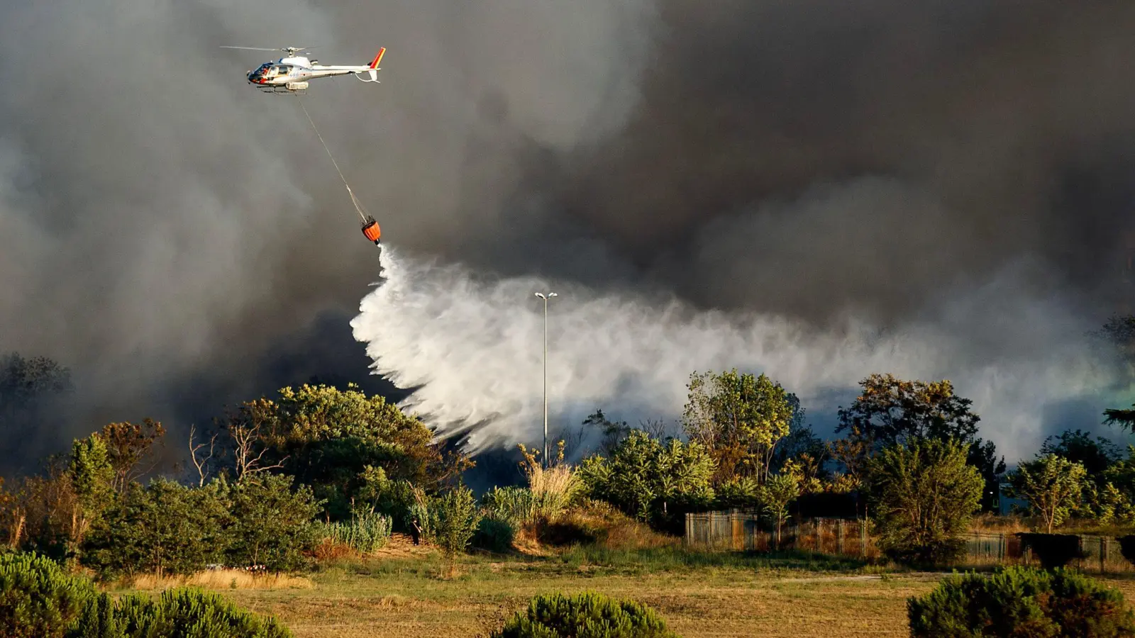 Ein Hubschrauber wirft Wasser ab, um ein Feuer im Centocelle-Park unweit von Rom zu löschen. (Foto: Lapresse / Roberto Monaldo/LaPresse via ZUMA Press/dpa)