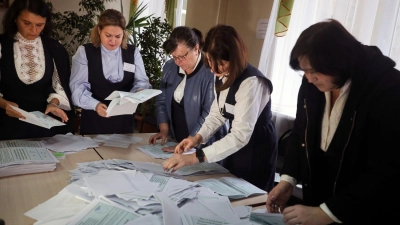 Mitglieder einer Wahlkommission zählen die Stimmzettel nach dem Scheinreferendum in einem Wahllokal in Donezk. (Foto: Uncredited/AP/dpa)