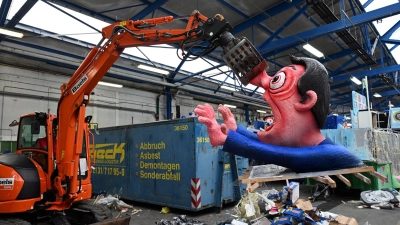 Ein Bagger hebt in Düsseldorf eine Pappfigur eines Rosenmontagszugs in den Müll. Nachdem die Motive zahlreiche Zuschauer begeisterten, werden sie abgerissen. (Foto: Federico Gambarini/dpa)