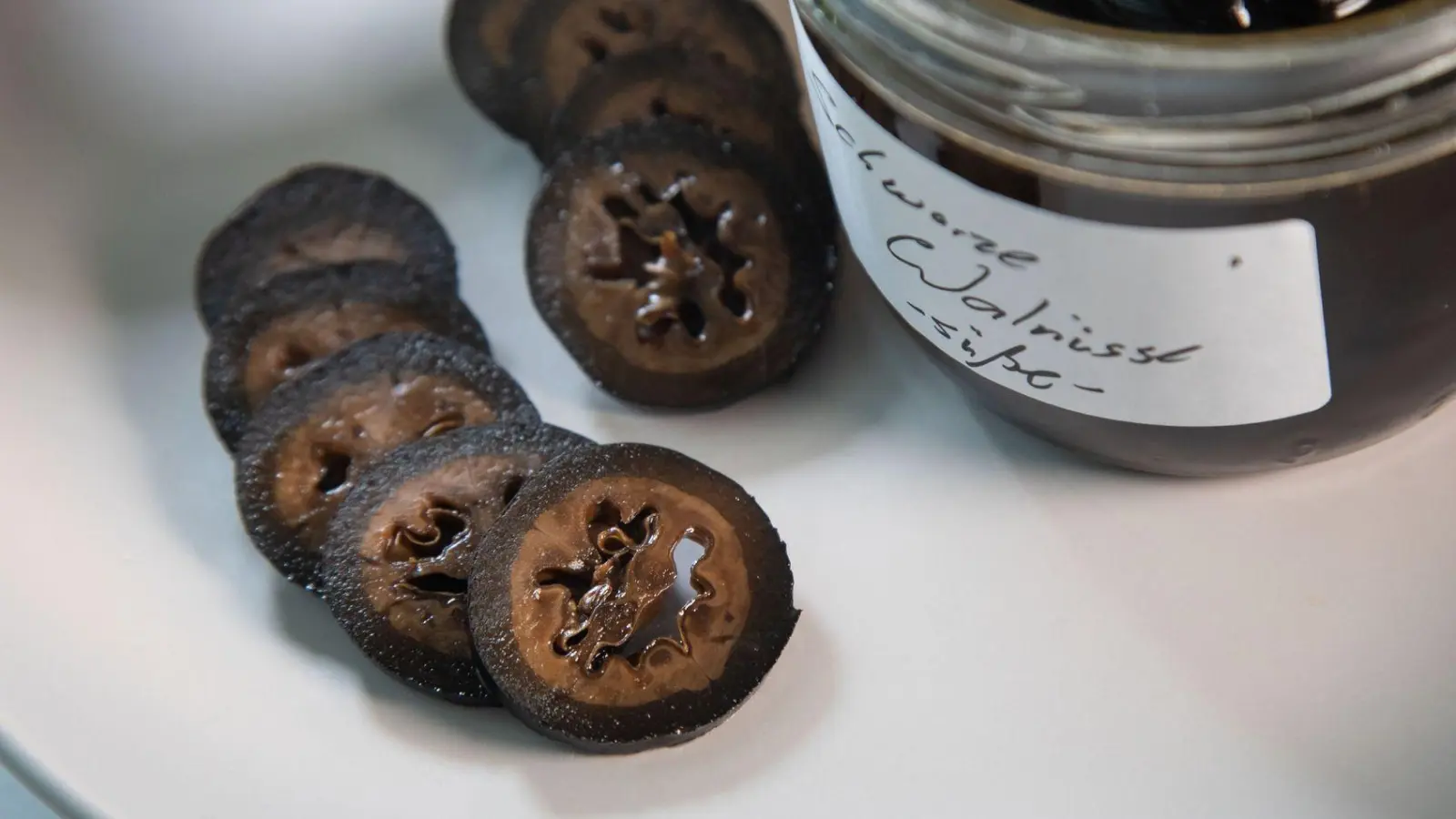 Frühstens an Weihnachten werden die in Gewürzsirup eingelegten schwarzen Walnüsse aufgeschnitten und werden als feines Topping für Eis oder Käse genutzt. (Foto: Christin Klose/dpa-tmn)