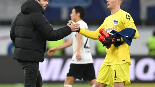 Cheftrainer Sandro Schwarz (l) von Hertha gibt Torwart Oliver Christensen nach dem Spiel die Hand. (Foto: Arne Dedert/dpa)