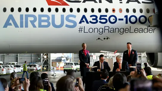 Qantas-CEO Alan Joyce (M, l) und Airbus-CEO Christian Scherer (M, r). Die australische Fluggesellschaft Qantas will ab Ende 2025 die längsten Nonstop-Flüge der Welt in ihr Streckennetz aufnehmen. (Foto: Bianca De Marchi/AAP/dpa)