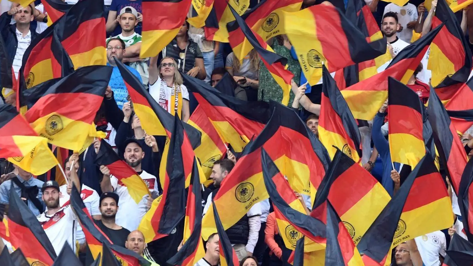 Fans schwenken Deutschlandfahnen auf der Tribüne. (Foto: Uli Deck/dpa)
