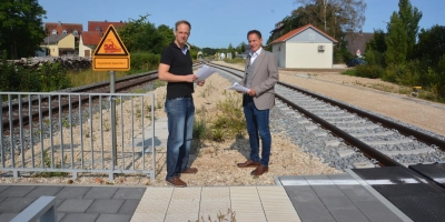 Das Begegnungsgleis ist fertig, das Stellwerk (im Hintergrund) auch. Peter Banczyk (links) von der „Verbindung zwischen Freunden“ und Wassertrüdingens Bürgermeister Stefan Ultsch (rechts) wundern sich nur noch über die Zeitverzögerungen. (Foto: Peter Tippl)