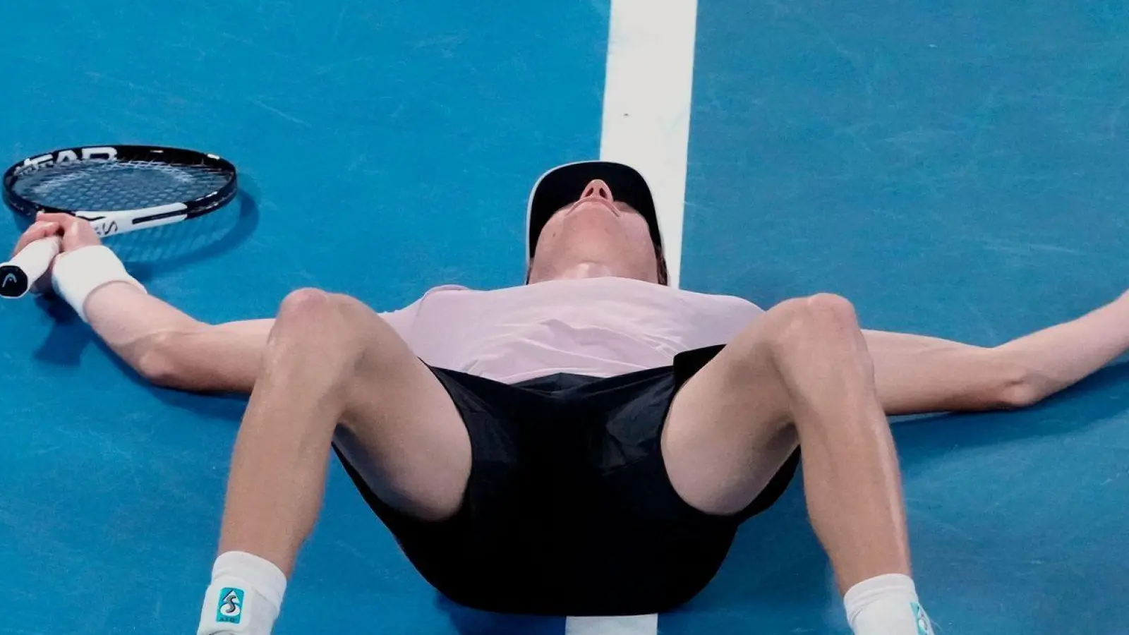 Jannik Sinner lässt sich nach seinem Triumph bei den Australian Open auf den Platz fallen. (Foto: Mark Baker/AP/dpa)