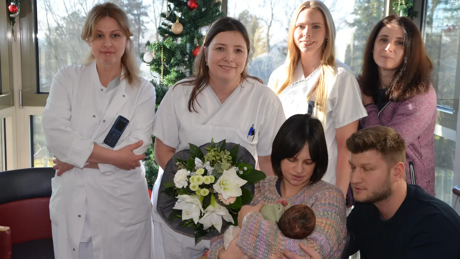 Am ersten Fototermin nahmen neben der Hauptperson Emil im Arm von Mutter Theresa und Papa Volker Bauereiß (vorne im Bild) auch die Ärztin Sophio Manjgaladze, Hebamme Sophia Kern (mit Blumenstrauß), Krankenschwester Marieluise Fries und die Oberärztin Avaliani Khatuna (hinten, von links) teil. (Foto: Christa Frühwald)