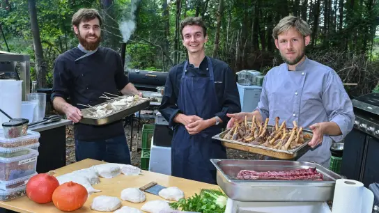 Emil Petersen (l-r), Simon Ortel und Ricco Stiehn sind die drei Jungs von der Eberswalder Kochkommode, hier bei einem Event in einer Parkanlage. (Foto: Patrick Pleul/dpa)