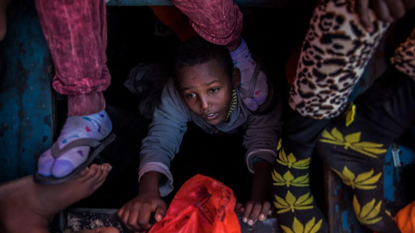 Ein Flüchtlingskind aus Eritrea versucht an der Küste zu Libyen, an Bord eines überfüllten Holzbootes hinaufzuklettern. (Foto: Santi Palacios/AP/dpa)