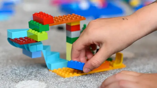 Ein Kind baut mit Lego-Steinen. (Foto: Tobias Hase/dpa/Symbolbild)