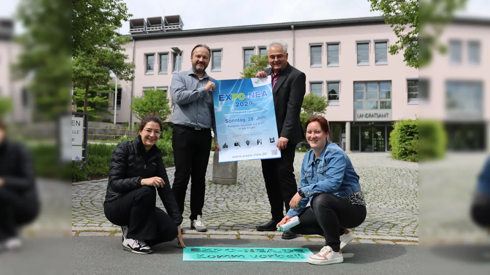Das Team der Wirtschaftsförderung am Landratsamt, bestehend aus Julia Tschawdarow (links unten), Claus Seifert (rechts stehend), Michael Capek und Stefanie Binder, präsentiert das Plakat für die erste Neustädter Expo.  (Foto: Patrick Lauer)