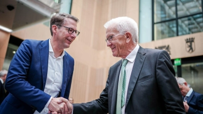 Markus Blume (l, CSU) und Winfried Kretschmann (Bündnis 90/Die Grünen) geben sich die Hand. (Foto: Kay Nietfeld/dpa)