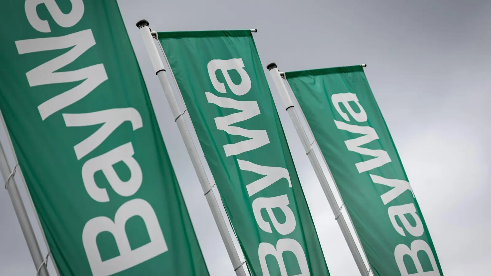 Baywa-Fahnen im Wind. Der Münchner Konzern befindet sich seit 2024 in einer stürmischen Phase. (Symbolbild) (Foto: Daniel Karmann/dpa)