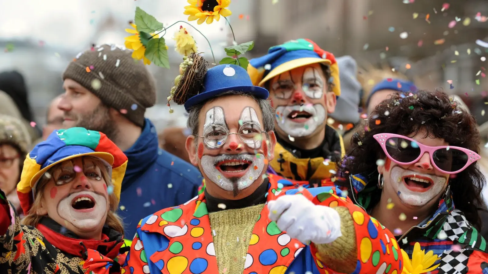Besucher in Clown-Kostümen werfen in Nürnberg beim Faschingsumzug mit Konfetti. (Foto: picture alliance / dpa/Archivbild)